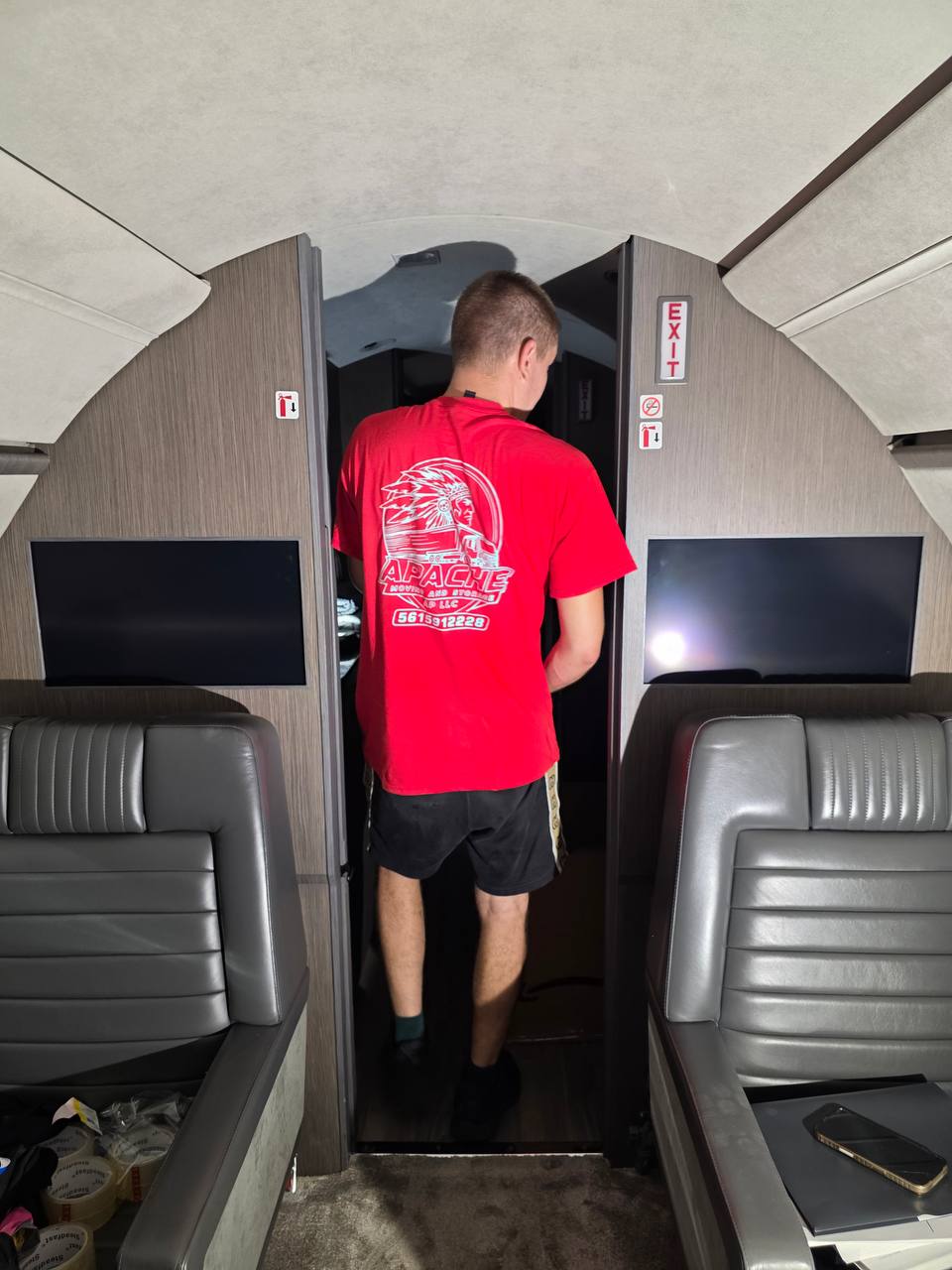 Apache Moving crew member moving through a private jet's mid-cabin corridor